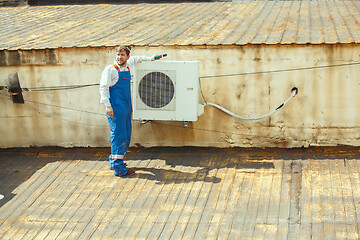 Image showing HVAC technician working on a capacitor part for condensing unit