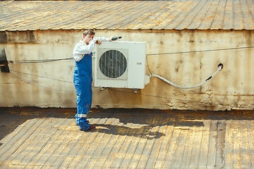 Image showing HVAC technician working on a capacitor part for condensing unit