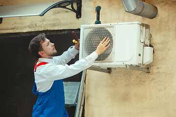 Image showing HVAC technician working on a capacitor part for condensing unit