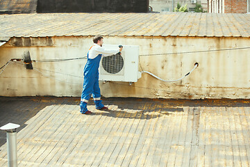 Image showing HVAC technician working on a capacitor part for condensing unit