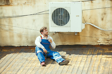 Image showing HVAC technician working on a capacitor part for condensing unit