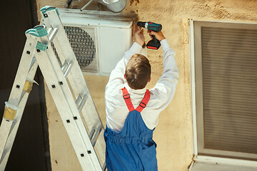 Image showing HVAC technician working on a capacitor part for condensing unit