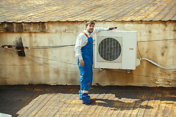 Image showing HVAC technician working on a capacitor part for condensing unit