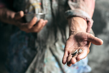 Image showing Male beggar hands seeking money on the wooden floor at public path way