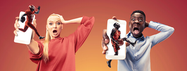 Image showing Portrait of people showing screen of mobile phone isolated over orange background