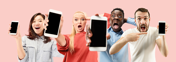 Image showing Portrait of people showing screen of mobile phone isolated over coral background