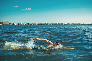 Image showing Professional triathlete swimming in river\'s open water