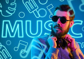 Image showing Beautiful young man isolated on studio background in neon light