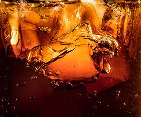 Image showing Close up view of the ice cubes in dark cola background
