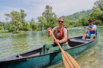 Image showing friends are canoeing in a wild river