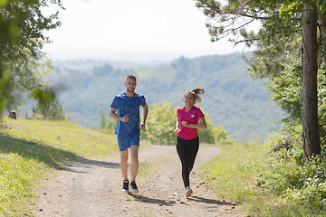 Image showing couple enjoying in a healthy lifestyle while jogging on a country road