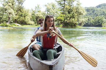 Image showing friends are canoeing in a wild river