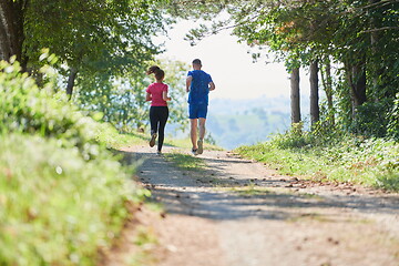 Image showing couple enjoying in a healthy lifestyle while jogging on a country road