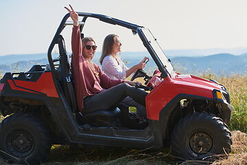 Image showing girls enjoying a beautiful sunny day while driving an off-road car