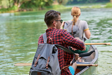 Image showing friends are canoeing in a wild river