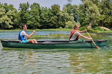 Image showing friends are canoeing in a wild river