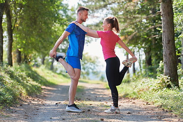 Image showing couple enjoying in a healthy lifestyle warming up and stretching before jogging