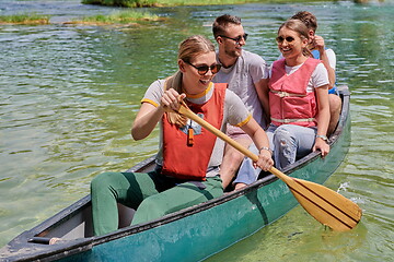 Image showing Group adventurous explorer friends are canoeing in a wild river