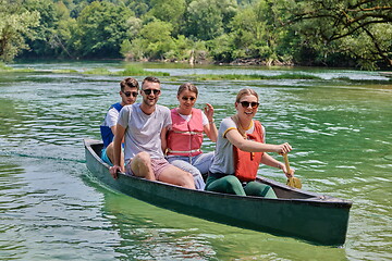 Image showing Group adventurous explorer friends are canoeing in a wild river