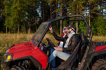 Image showing two young happy excited men enjoying beautiful sunny day while driving a off road buggy car