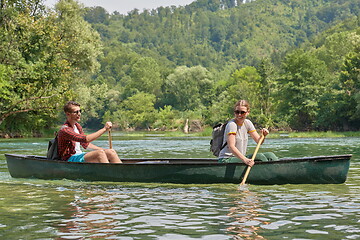 Image showing friends are canoeing in a wild river