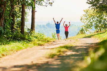 Image showing couple enjoying in a healthy lifestyle while jogging on a country road