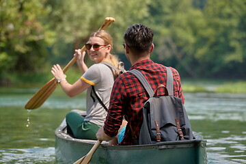 Image showing friends are canoeing in a wild river