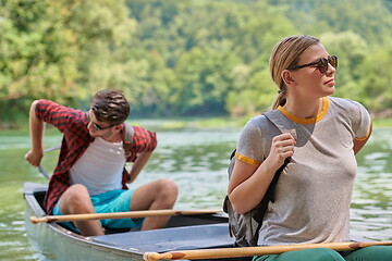 Image showing friends are canoeing in a wild river