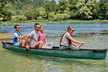 Image showing Group adventurous explorer friends are canoeing in a wild river