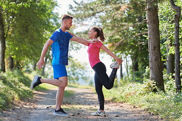 Image showing couple enjoying in a healthy lifestyle warming up and stretching before jogging