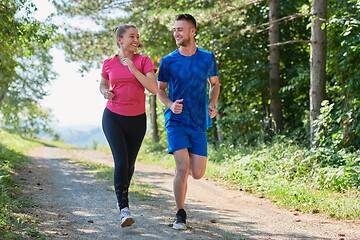 Image showing couple enjoying in a healthy lifestyle while jogging on a country road