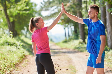 Image showing couple enjoying in a healthy lifestyle while jogging on a country road