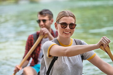 Image showing friends are canoeing in a wild river