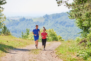 Image showing couple enjoying in a healthy lifestyle while jogging on a country road