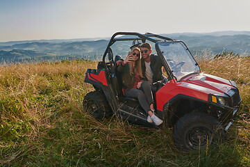 Image showing couple enjoying beautiful sunny day taking selfie picture while driving a off road buggy