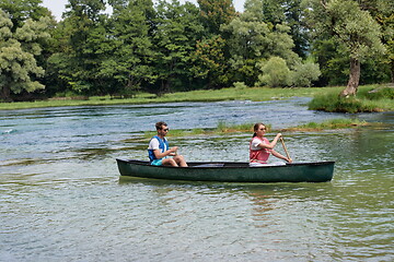 Image showing friends are canoeing in a wild river