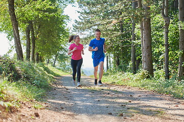 Image showing couple enjoying in a healthy lifestyle while jogging on a country road