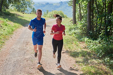 Image showing couple enjoying in a healthy lifestyle while jogging on a country road