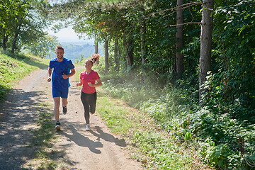 Image showing couple enjoying in a healthy lifestyle while jogging on a country road