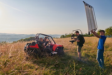 Image showing cameraman recording a young couple enjoying a buggy car ride up a mountain