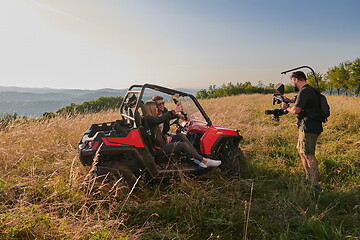 Image showing cameraman recording a young couple enjoying a buggy car ride up a mountain