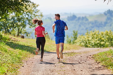 Image showing couple enjoying in a healthy lifestyle while jogging on a country road