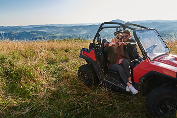 Image showing couple enjoying beautiful sunny day taking selfie picture while driving a off road buggy