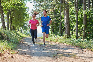 Image showing couple enjoying in a healthy lifestyle while jogging on a country road