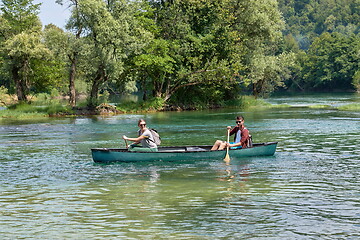 Image showing friends are canoeing in a wild river