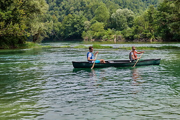 Image showing friends are canoeing in a wild river