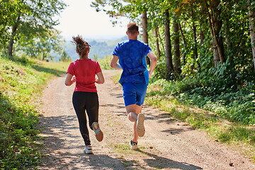 Image showing couple enjoying in a healthy lifestyle while jogging on a country road