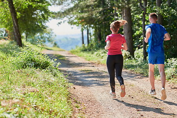 Image showing couple enjoying in a healthy lifestyle while jogging on a country road