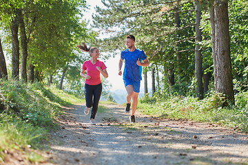 Image showing couple enjoying in a healthy lifestyle while jogging on a country road