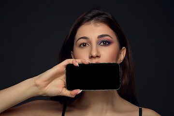 Image showing Lie and another life in social media. Girl with make up only on half of her face. Playing pretend. Blank phone screen.